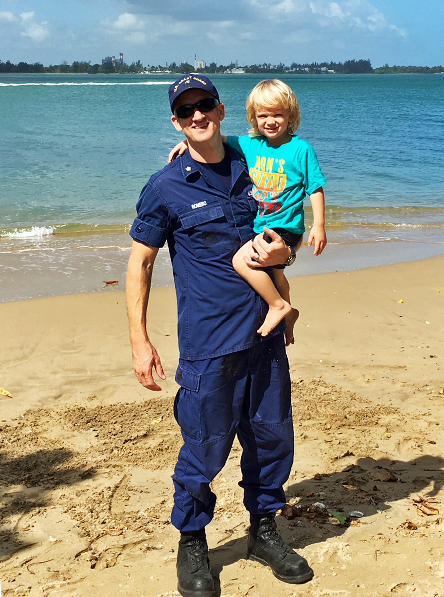 Owner, Ryan Romero, Holding Son on the Beach